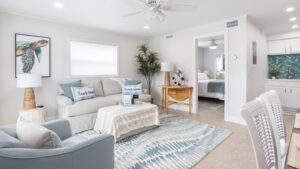 White and blue living room with door open to bedroom.
