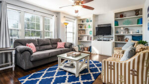 Small hardwood floor living room with gray and brown striped couch.