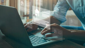 Man managing property rental info on laptop.